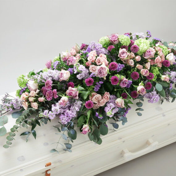 Fargerik blomsterdekorasjon på en hvit kiste