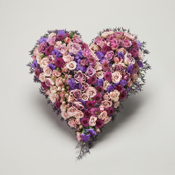 Rosa og lille blomsterdekorasjon i hjerteform