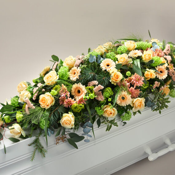 Fargerik blomsterdekorasjon på en hvit kiste