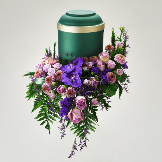 En blomsterdekorasjon i forskjellige farger med en urne plassert på toppen.